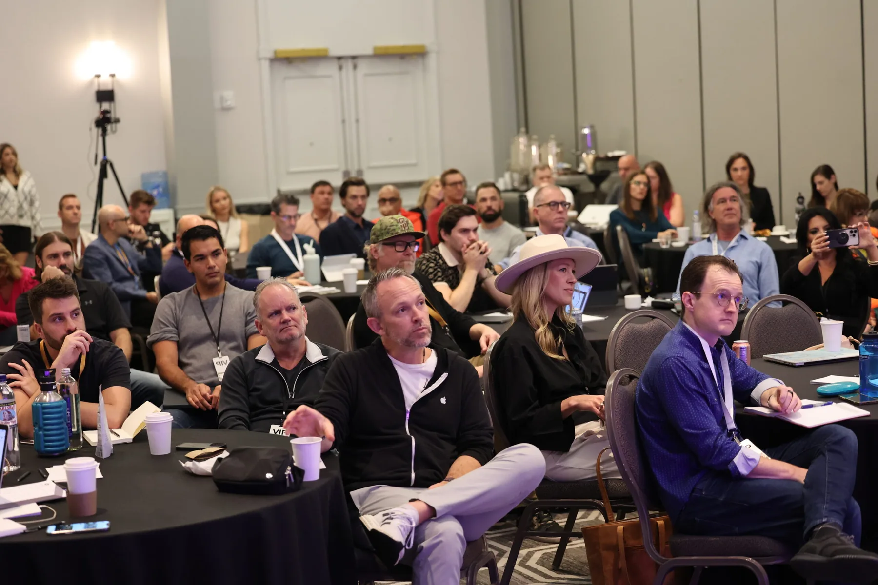 Members at round tables listening to a session