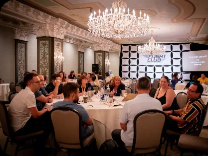 Members at dinner in a chandelier-lit ballroom