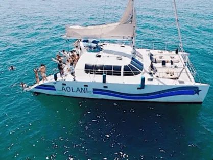 Members aboard a catamaran on open blue water