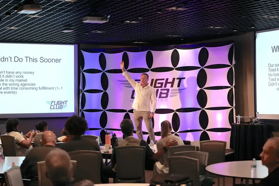 A speaker presenting a slide of lessons learned to the room